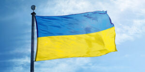 Image of a Ukrainian flag waving in front of a blue sky