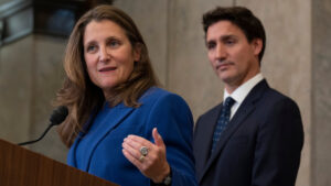 Chrystia Freeland makes and announcement, with Justin Trudeau standing behind her